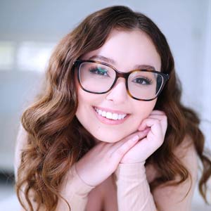 Smiling for the camera in her glasses