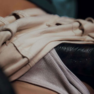 Reaching under her skirt