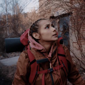 With her jacket and backpack on